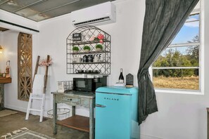 A compact kitchen with a vintage Galanz refrigerator, a coffee machine, and a wine rack with potted plants. - Coco Casita - Hot Tub & Fire Pit (Fredericksburg)