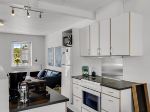 A modern kitchen with white cabinets, a black countertop, and a built-in oven. - "Alwina" - 900m from the sea by Interhome (Bindslev)