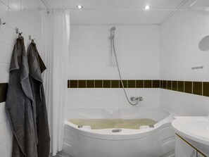 A bathroom with a bathtub, a shower, and a sink. - "Alwina" - 900m from the sea by Interhome (Bindslev)