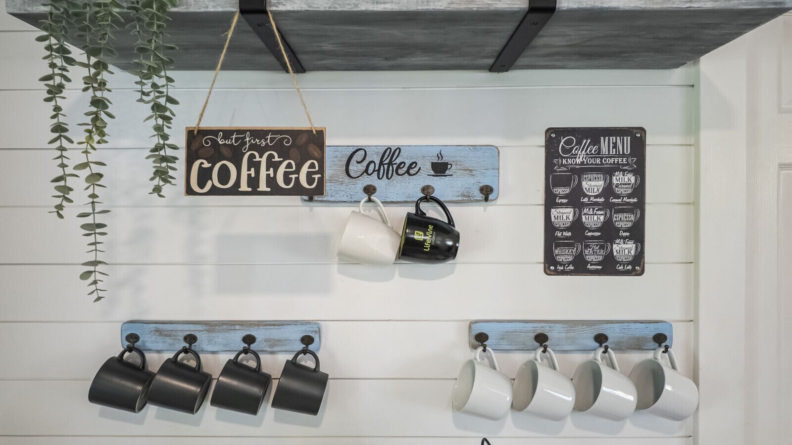 A wall with coffee-themed decorations, including signs and mugs.