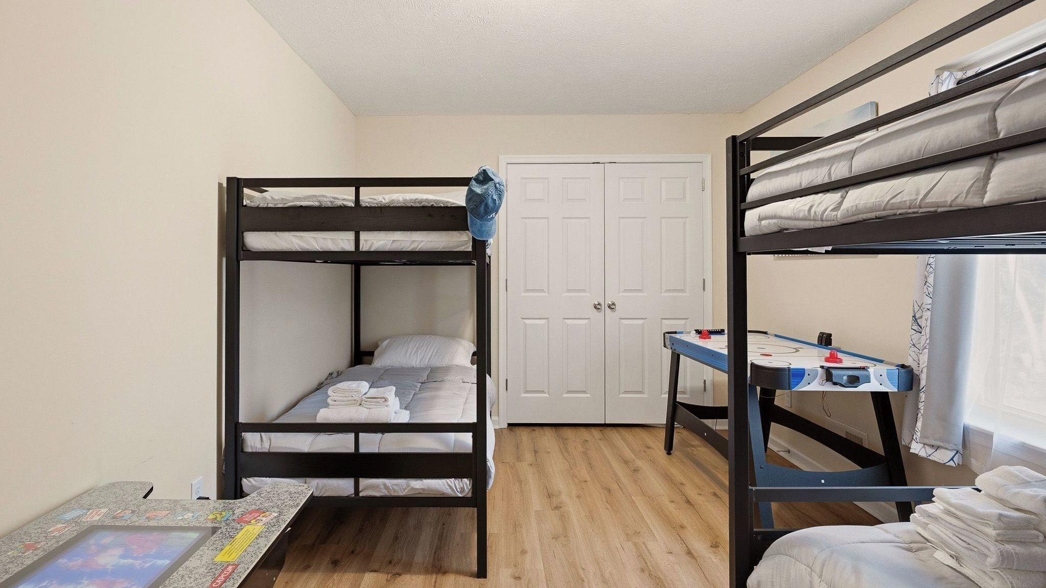 A bunk bed room with a desk and a door.