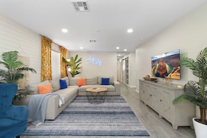 A living room with a sofa, coffee table, and potted plants. - Desert Diamond - Scottsdale 4 BR, Pool, Fire Pit, Ping Pong and games (Scottsdale)