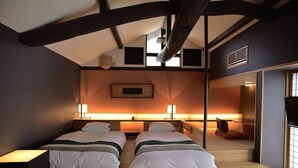 A bedroom with two beds, a ceiling fan, a mounted picture, and a sliding door leading to a bathroom. - Shimayado Mari (Shodoshima)