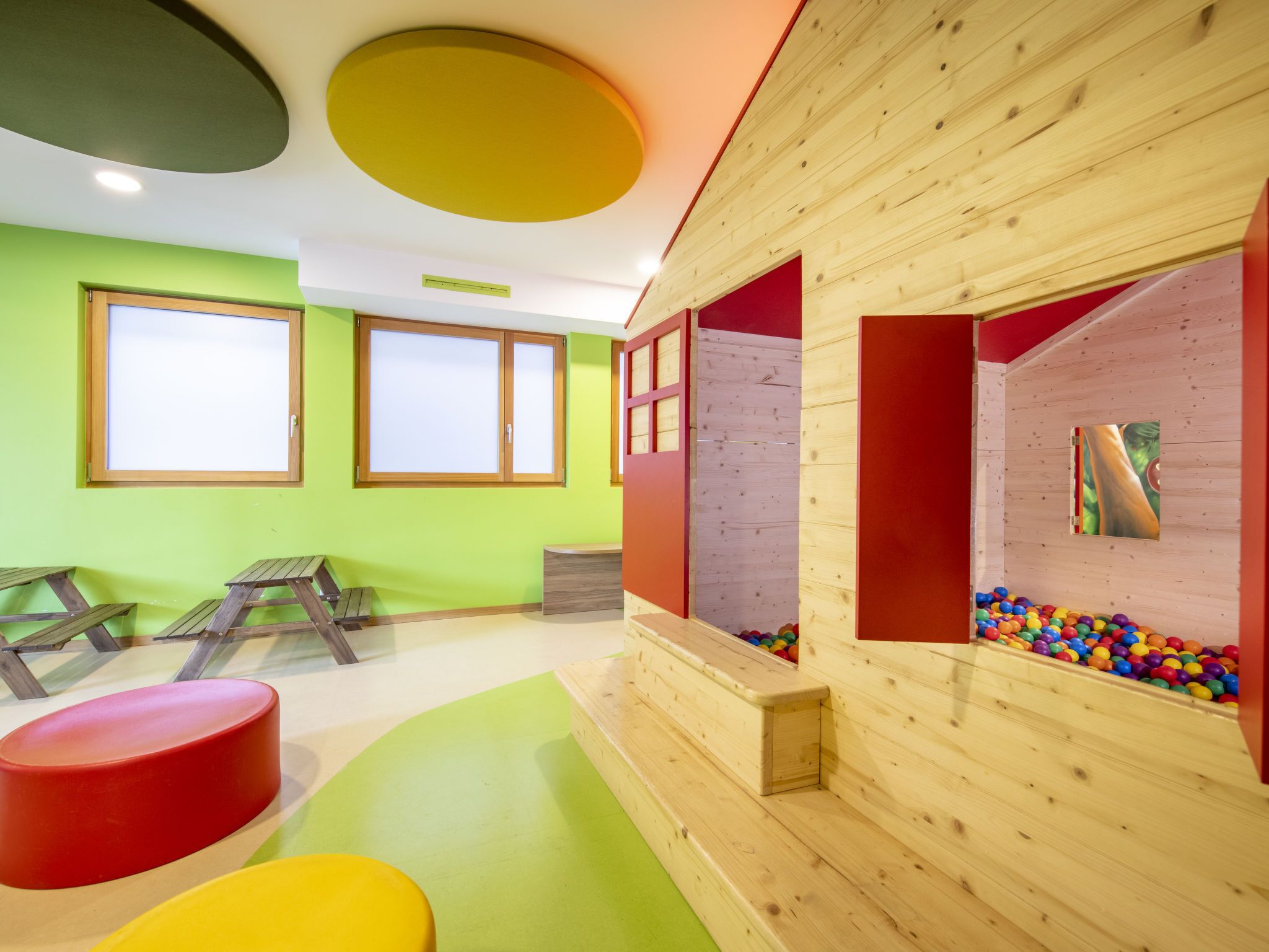 A play area with climbing walls, colorful balls, and wooden play structures.