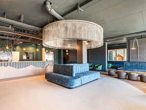 A modern reception area with a curved seating arrangement, a large woven light fixture, and a reception desk. - SWISSPEAK Resorts Thyon 4 Vallées by Interhome (Thyon-Les Collons)