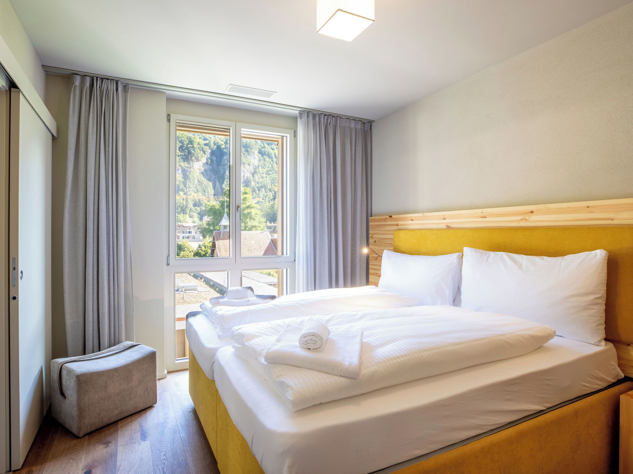 Une chambre d’hôtel avec un lit, un petit coin salon et une fenêtre avec des rideaux.