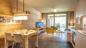 Eine moderne Küche mit Essbereich, Holzwänden und einem Fernseher.