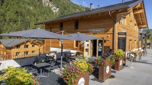 Ein Holzgebäude mit dem Schild 'The Bistro' und Außenbereich mit Sonnenschirmen.