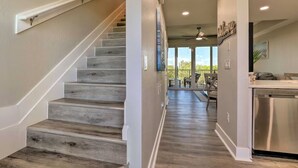 A staircase leading to a living area with a view of the outdoors. - Bahia Beach Calm Ruskin Retreat (Ruskin)
