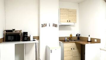 Coffee/tea maker, microwave, cookware/dishes/utensils, dining tables