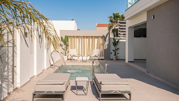 A rooftop pool area with two sun loungers, a small pool, and a bamboo wall. - The Ekfrasis- Mossa Concept Villas (Chania)