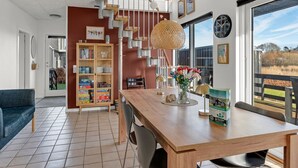 A modern interior with a wooden dining table, a bookshelf, and a staircase. - "Angret" - 380m from the sea by Interhome (Humble)