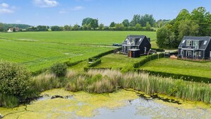 A rural landscape with two houses, a field, and a pond with a swan. - "Angret" - 380m from the sea by Interhome (Humble)