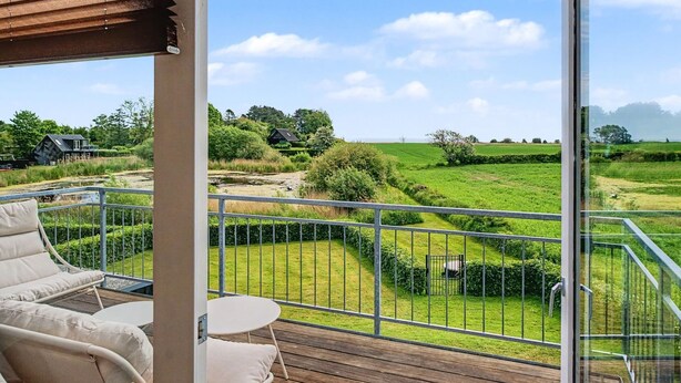 A balcony with a view of a green landscape, a small table, and two chairs. - "Angret" - 380m from the sea by Interhome (Humble)