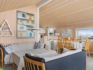 A cozy interior with a dining area, kitchen, and a large window with a view.