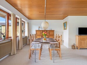 A dining area with a round table, chairs, a chandelier, a television, and a view of the outside. - "Wildemor" - 30km from the sea by Interhome (Løgumkloster)