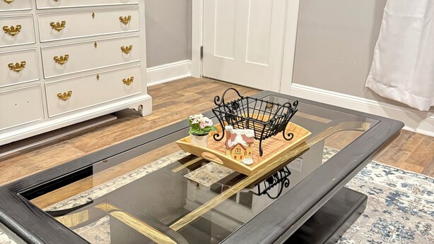 A room with a glass-top coffee table, a white dresser with gold handles, a white door, and a patterned rug. - Entire Private Home • Sleeps 6 • Prime Salisbury Location (Salisbury)