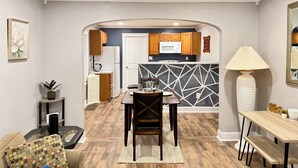 A modern kitchen with wooden cabinets, a microwave, and a black backsplash. - Entire Private Home • Sleeps 6 • Prime Salisbury Location (Salisbury)