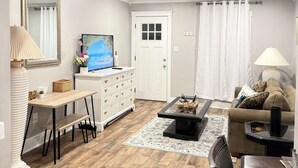 A living room with a dining area, a TV, a white door, and a large mirror. - Entire Private Home • Sleeps 6 • Prime Salisbury Location (Salisbury)