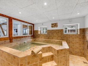 A spa area with a stone-tiled floor, a glass-enclosed hot tub, and a wooden-framed window. - "Blaguna" - 9km to the fjord by Interhome (Tarm)