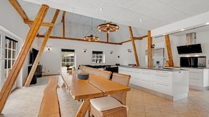 A spacious kitchen with a long wooden table, white cabinets, and a large island. - "Blaguna" - 9km to the fjord by Interhome (Tarm)