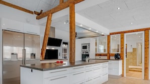 A modern kitchen with a large island, built-in appliances, and wooden beams. - "Blaguna" - 9km to the fjord by Interhome (Tarm)