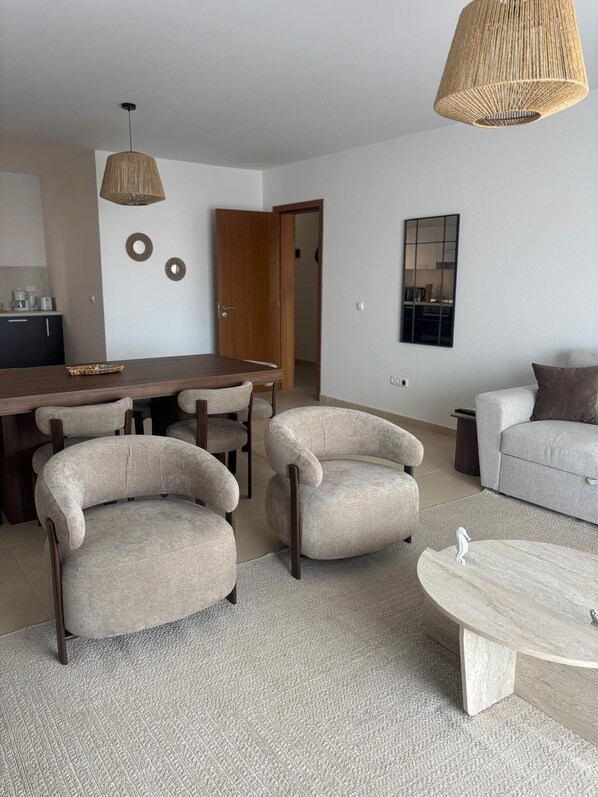 Una sala de estar moderna con comedor, un sofá y una mesa de centro.