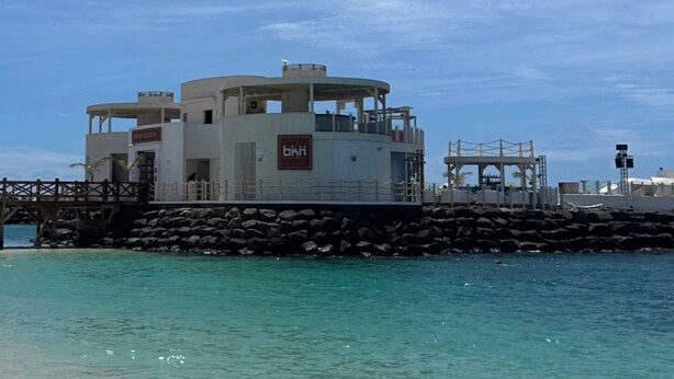 Un bâtiment situé au bord de l’eau, avec une enseigne indiquant « biki » et une jetée s’avançant dans l’eau.