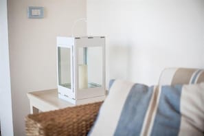 Une lanterne blanche sur une table blanche, avec un panier au premier plan.