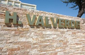 Un mur de pierre sur lequel est gravée l’inscription « H. VALVERDE » en lettres majuscules.