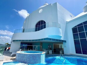 Ein modernes Hotel mit Pool, Außenbereich und einem großen Panoramafenster.