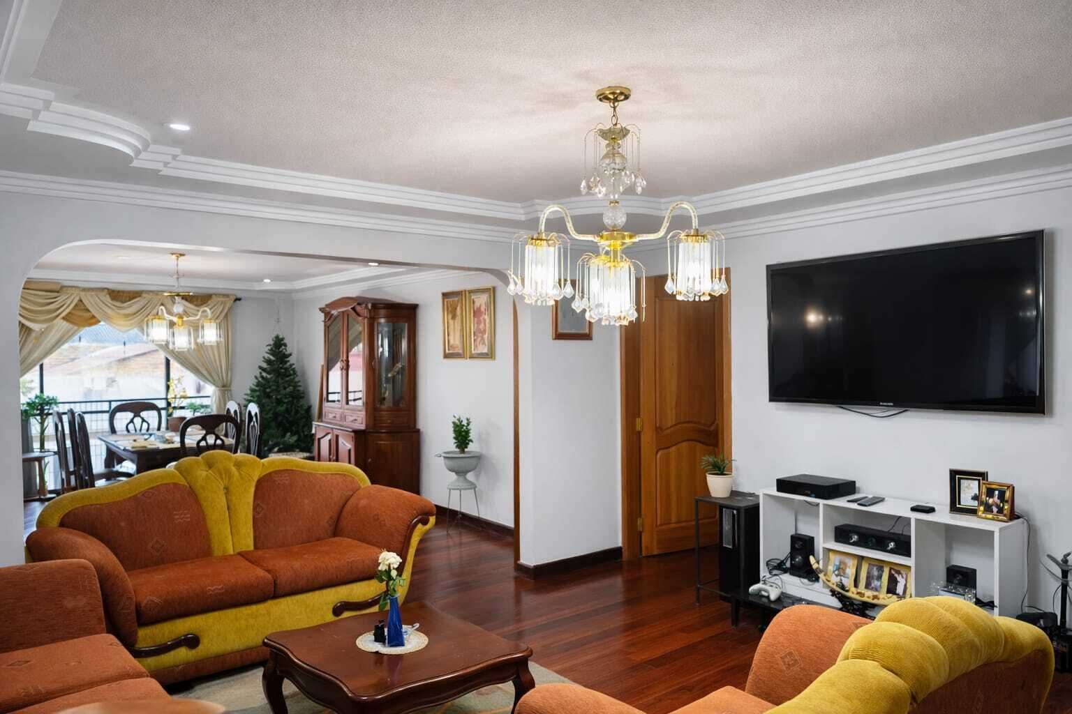 Un salon avec un canapé, une table basse, un téléviseur et un meuble.