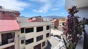 Ein mehrgeschossiges Gebäude mit Balkonen, einem roten Dach und blauem Himmel.