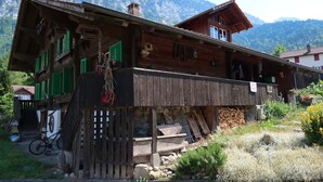 A wooden house with a balcony, a bicycle, and a mountain backdrop. - Lakeview Chalet 1 , Därligen (Darligen)