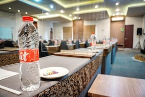 A conference room with tables, chairs, and a bottle of water on one table. - Hotel Andelir (Semarang)