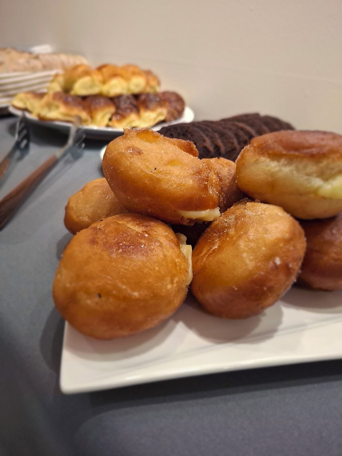 Une assiette de viennoiseries dorées et croustillantes sur une table.