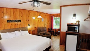 Une chambre d’hôtel équipée d’un lit, d’une chaise, d’une table, d’un four à micro-ondes et d’un réfrigérateur.