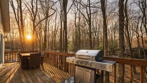 A wooden deck with a grill and outdoor furniture. - Beach + Lake Access | AC, Game Room, Fire Pit (Albrightsville)