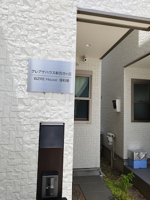 A building entrance with a sign indicating 'WZRE House' and a security camera.