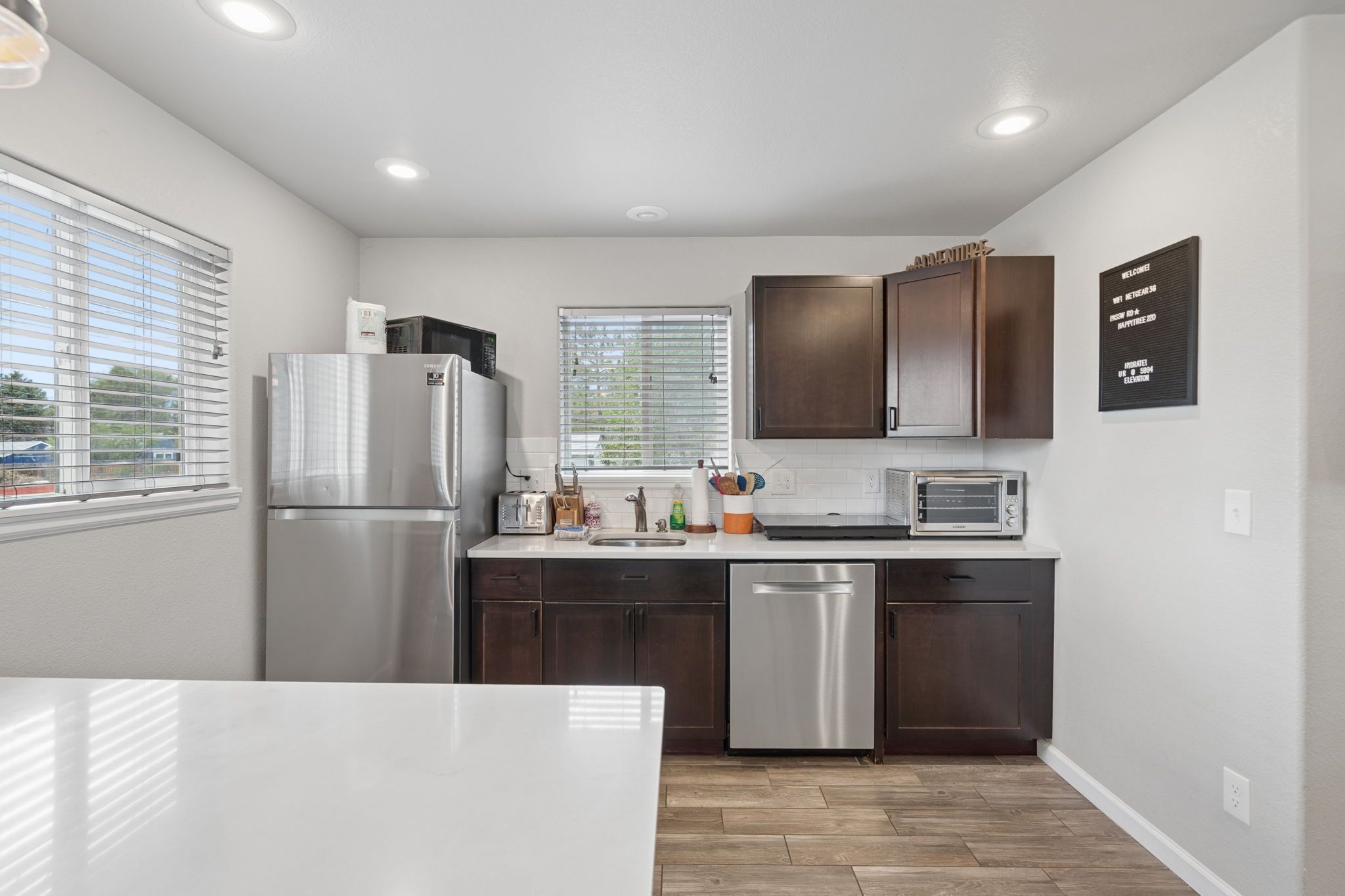 A compact kitchen with a refrigerator, dishwasher, and a toaster.