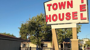 A motel sign with the words 'MOTEL' and 'TOWN HOUSE' in bold letters. - Townhouse Motel (Tracy)