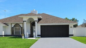 A single-story house with a garage, a front porch, and a well-maintained lawn. - ☆☀︎❀Paradise! Pool Table, Sauna, Boat Parking, Fenced Yard, Near Boat Launch (Sebastian)