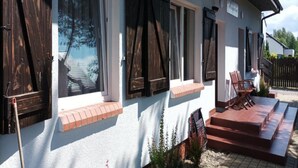 A building with large windows, a brick entrance, and a small outdoor seating area. - Studio for 2 People, Rowy (Ustka)