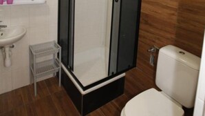 A bathroom with a toilet, a sink, and a shower enclosure. - Studio for 2 People, Rowy (Ustka)