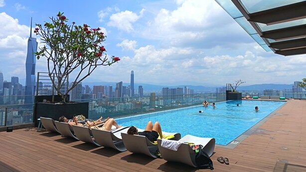 A rooftop pool with lounge chairs, a potted plant, and a city skyline view. - KL Sentral, Kuala Lumpur, 4 pax Family Merdeka 118 Nice View, , Sky Pool MRT LRT (Kuala Lumpur)
