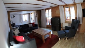 En stue med sofa, lænestol, sofabord og fjernsyn.