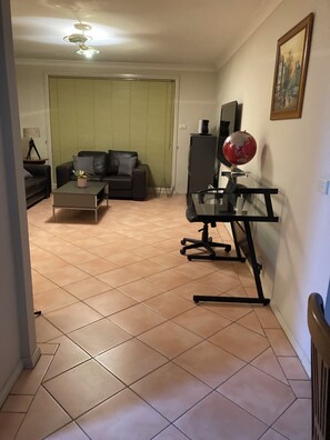 Una sala de estar con sofá, mesa de centro y escritorio con un globo terráqueo.