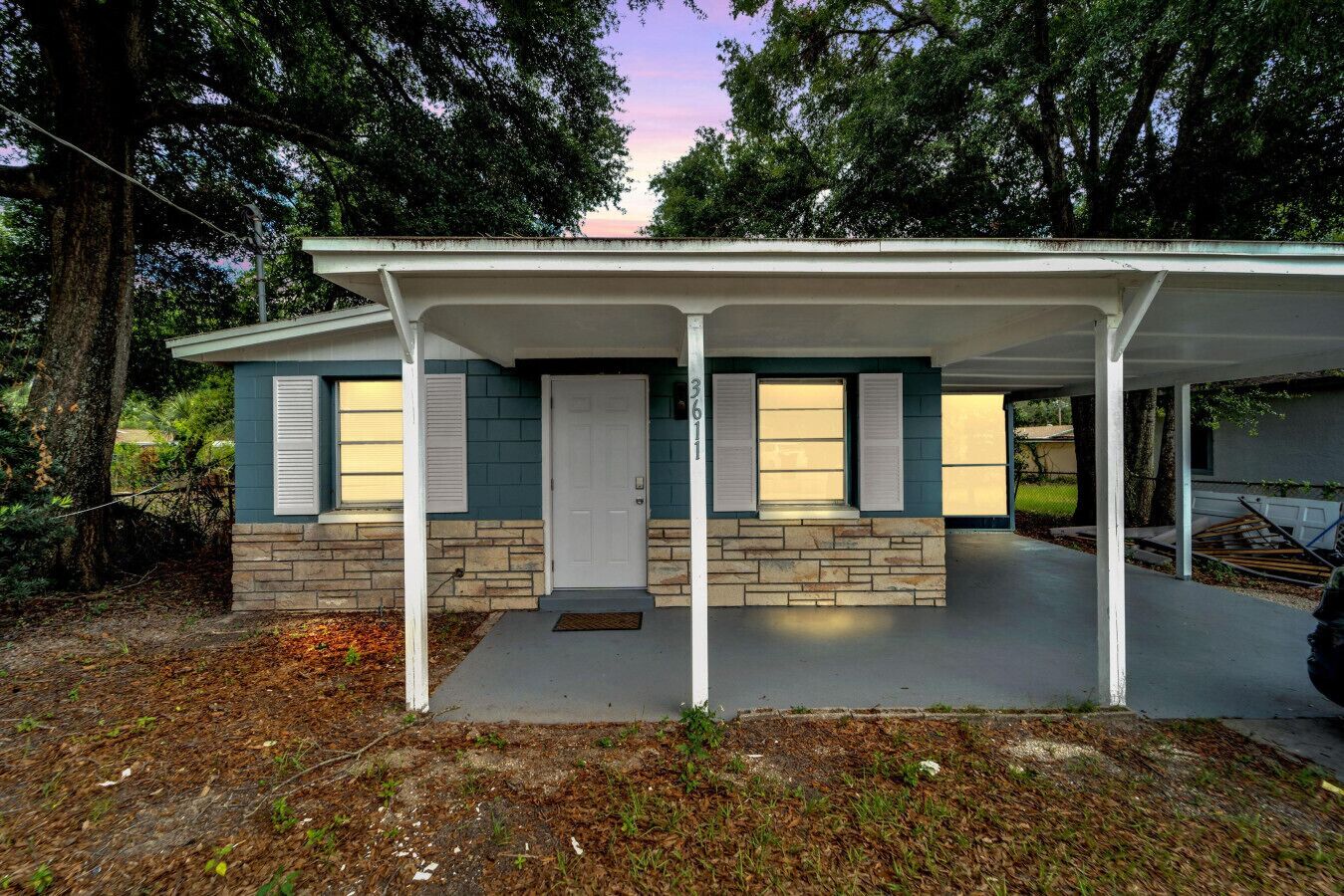 A single-story house with a porch, a front door, and a mailbox.