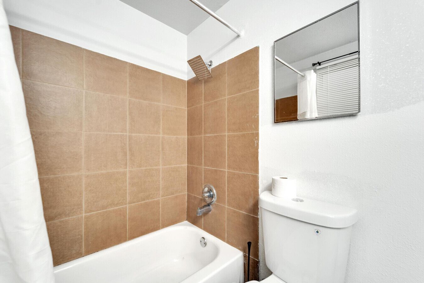 A bathroom with a bathtub, a toilet, and a shower.