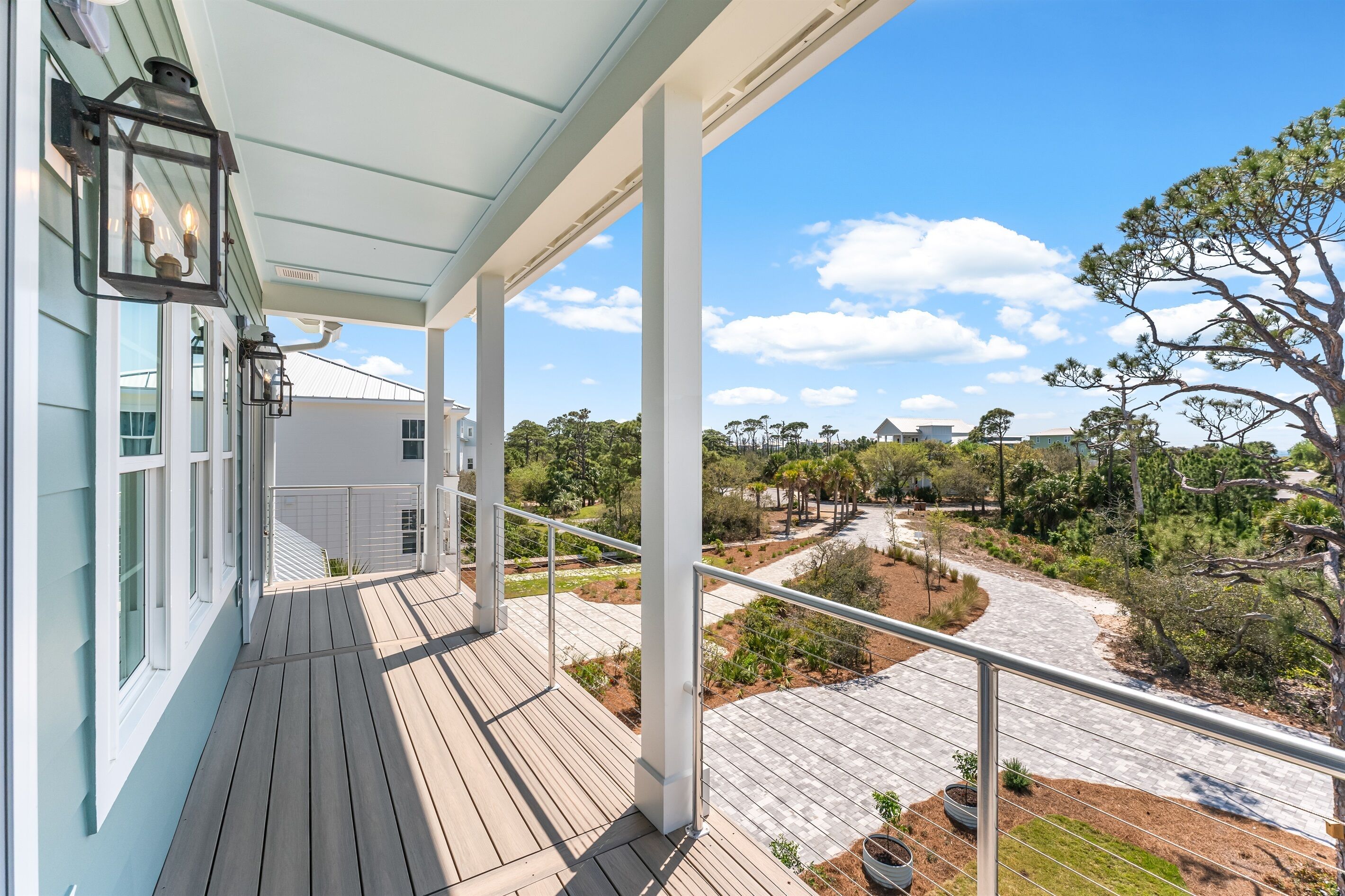 A balcony with a view of a landscaped garden and distant buildings.